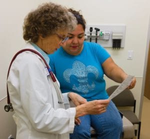 Sr. Rosanne Popp M.D. explains prescription to a female patient