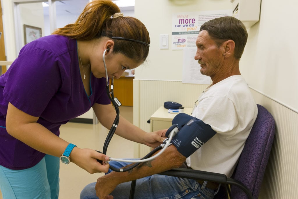 St. Mary's Clinic medical professional takes patient's blood pressure