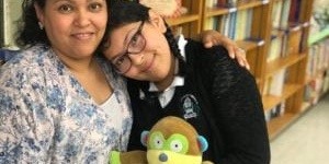 Mia Hernandez rests her head on her mother's shoulder, holding on to the stuffed monkey that helped her during a terrible health scare